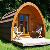 une petite cabane en bois avec deux chaises dans l&#39;herbe dans l&#39;établissement Camping Padimadour, à Rocamadour