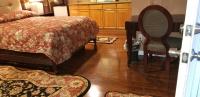a bedroom with a bed and a chair and wooden floors at Sea Haven Resort Motel in Southampton