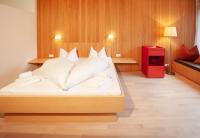 a bedroom with a large bed with white sheets at Bonawinkel NEU in Gaschurn