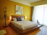 a bedroom with a large bed with yellow walls at The Deer Head Inn in Kenting