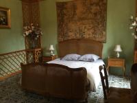 a bedroom with a bed and a tapestry on the wall at Le Manoir in Tarare