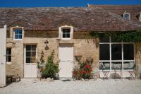 a brick building with two white doors and flowers at Le Domaine de l&#39;Hostellerie in Le Fresne-Camilly