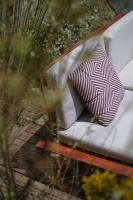 a white couch with a red and white pillow on it at Le Domaine de l&#39;Hostellerie in Le Fresne-Camilly