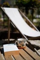 a coffee cup sitting on a wooden table with a book at Le Domaine de l&#39;Hostellerie in Le Fresne-Camilly