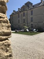 a large castle with two lawn chairs in front of it at Le Domaine de l&#39;Hostellerie in Le Fresne-Camilly