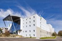 a large white building with a curved roof at Sure Hotel by Best Western Nantes Beaujoire in Nantes