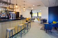 a restaurant with a bar with chairs and tables at Sure Hotel by Best Western Nantes Beaujoire in Nantes