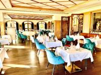 Un comedor con mesas blancas y sillas azules. en Hotel Tanneck, en Bad Wörishofen