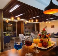 吉达Signature Guest Hotel فندق إمضاء النزيل الفندقية的桌子上放着三杯葡萄酒和一些水果。