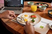 uma pessoa sentada numa mesa com um prato de comida para o pequeno-almoço em ibis styles Lima San Isidro em Lima