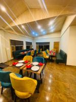 a dining room with tables and chairs in a room at Hotel Alpine Musk in Kanatal