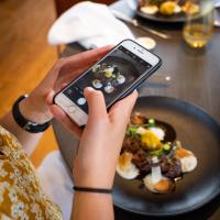 uma pessoa tirando uma foto de um prato de comida em Martin's Château Du Lac em Genval