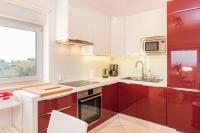 a kitchen with red and white cabinets and a window at SEA VIEW APARTMENT in Ližnjan