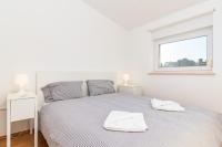 a white bedroom with a bed with two towels on it at SEA VIEW APARTMENT in Ližnjan