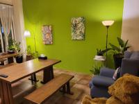 a living room with green walls and a wooden table at Slowly B&amp;B in Taitung City