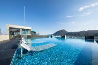 a swimming pool with chairs on the roof of a building at AMANEK Beppu YULA-RE in Beppu