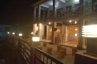 ein Gebäude mit Lichtern und einem Balkon bei Nacht in der Unterkunft Kumaon Gud Chaha Cafe & Homestay in Chaukori