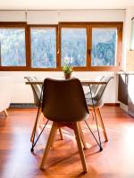 una mesa y sillas en una habitación con ventanas en Apartamento moderno Estanyó con vistas en Arinsal, en Mas de Ribafeta
