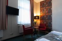 a hotel room with a bed and two chairs and a window at Hotel Polonia - Frankfurt&#47;Oder in Frankfurt Oder