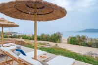 un patio con sombrilla y sillas y vistas al océano en Boutique hôtel Château Rouher, en Propriano