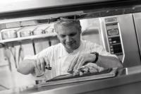 Un hombre en una cocina preparando comida en un mostrador. en Hotel Lou Granva, en Grande Riviere