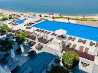 Una vista aérea de una piscina con sillas y sombrillas y el océano. en Porto dead sea, en Sowayma
