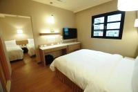 a hotel room with two beds and a mirror at Kindness Hotel - Kaohsiung Main Station in Kaohsiung