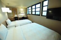 a hotel room with two beds and a flat screen tv at Kindness Hotel - Kaohsiung Main Station in Kaohsiung