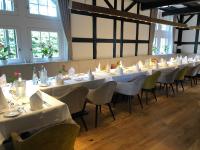 SaerbeckにあるLandhaus Bruckmannの白いテーブルと椅子、窓が備わる客室です。