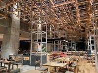 a restaurant with wooden tables and chairs and ceilings at AMANEK Beppu YULA-RE in Beppu