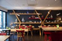 une salle à manger avec des tables en bois et des chaises rouges dans l&#39;établissement Colmar Hotel, à Colmar