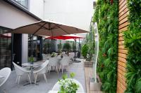 d&#39;une terrasse avec des tables, des chaises et un parasol. dans l&#39;établissement Colmar Hotel, à Colmar