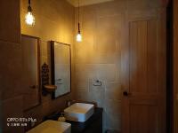 a bathroom with a sink and a toilet and a mirror at Sunnylands B&amp;B 日光小鎮民宿 in Dayin