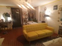 sala de estar con sofá amarillo y mesa en Bienvenue, en Saint-Pierre-de-Plesguen