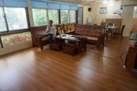 a man sitting in a room with wooden furniture at Ji Ji Farm Homestay in Jiji