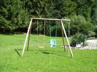 a swing set in a yard with a green lawn at LA PARENTHÈSE AU PAYS DU VERT in Soucht