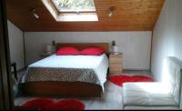 a bedroom with a bed with red pillows and a window at LA PARENTHÈSE AU PAYS DU VERT in Soucht