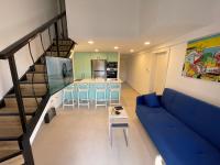 ein Wohnzimmer mit einer blauen Couch und einer Küche in der Unterkunft Top Royal Eilat רויאל פארק in Eilat