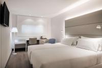 a hotel room with a large white bed and a desk at NH Ciudad Real in Ciudad Real