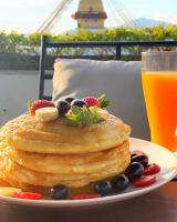 a plate of pancakes with fruit and a glass of orange juice at Hotel Bodhiz in Kathmandu