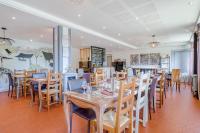 una sala da pranzo con tavoli e sedie in legno di Logis Hotel Maison Carrée Restaurant O Carré dArt a Méréville