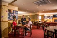 eine Gruppe von Menschen, die an Tischen in einem Restaurant sitzen in der Unterkunft Llanrhidian Holiday Park in Llanmorlais