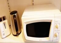 a microwave and a cell phone sitting on a counter at La Maison de Ville indépendante My Bastide Classée in Villefranche-de-Rouergue