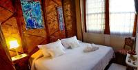 a bedroom with a bed with white sheets and pillows at Pousada Arte Urquijo in Paraty