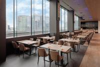 Un restaurante con mesas y sillas y grandes ventanales. en Yokohama Tokyu REI Hotel, en Yokohama