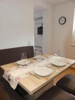 una mesa de madera con platos y copas de vino. en Apartment Stefanie by Interhome, en Taxenbach
