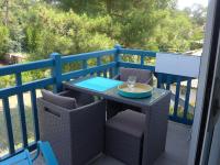 a table with chairs and a glass on a balcony at Apartment Les Berges Landaises-1 by Interhome in Soorts-Hossegor