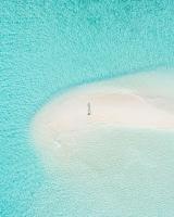 a person standing on a small island in the ocean at Beach Stone in Gulhi