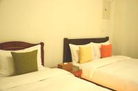 a bedroom with two beds and a nightstand between them at East of Love Homestay in Hualien City
