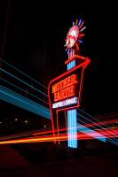 un letrero de neón para un restaurante con un reloj en él en Mother Earth Motor Lodge, en Kinston